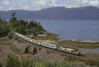 Scenic view of Class 37 hauling Class 101 observation saloon and coaches with a Loch and hills behind
